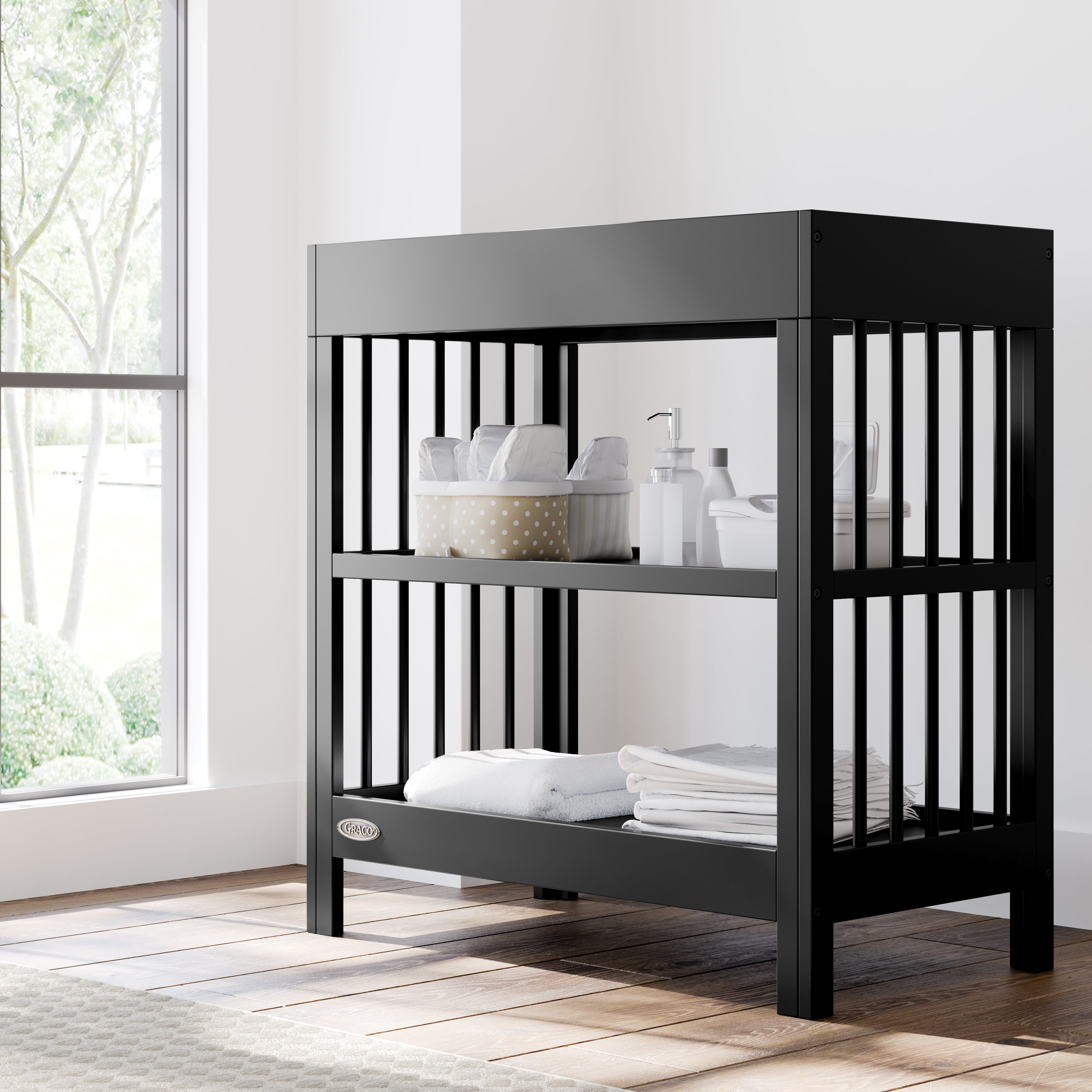 teddi black changing table in nursery with changing essentials on both shelves