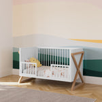 white and vintage driftwood crib toddler bed conversion with two guardrail in nursery