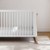 white with driftwood crib in nursery