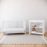 White crib and changing table in a nursery