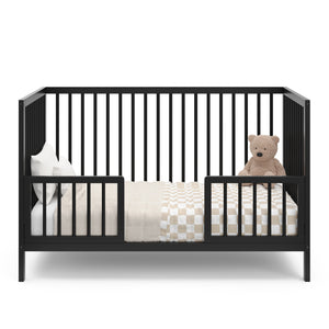 Black crib in toddler bed conversion with two guardrail