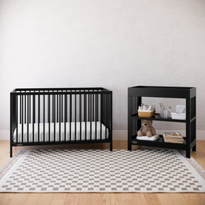 Black crib and changing table in a nursery