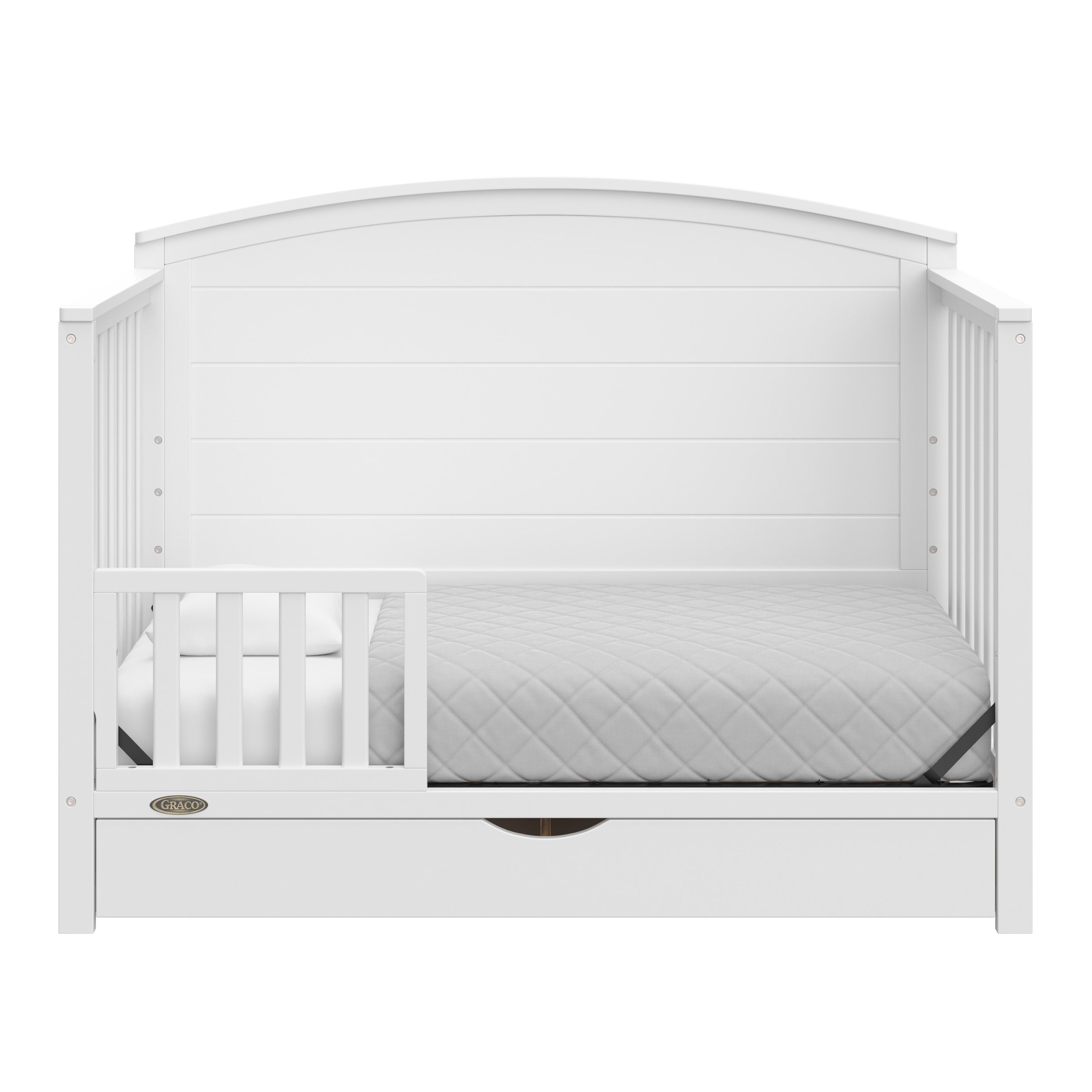 Convertible white crib transformed into a toddler bed with one guardrails