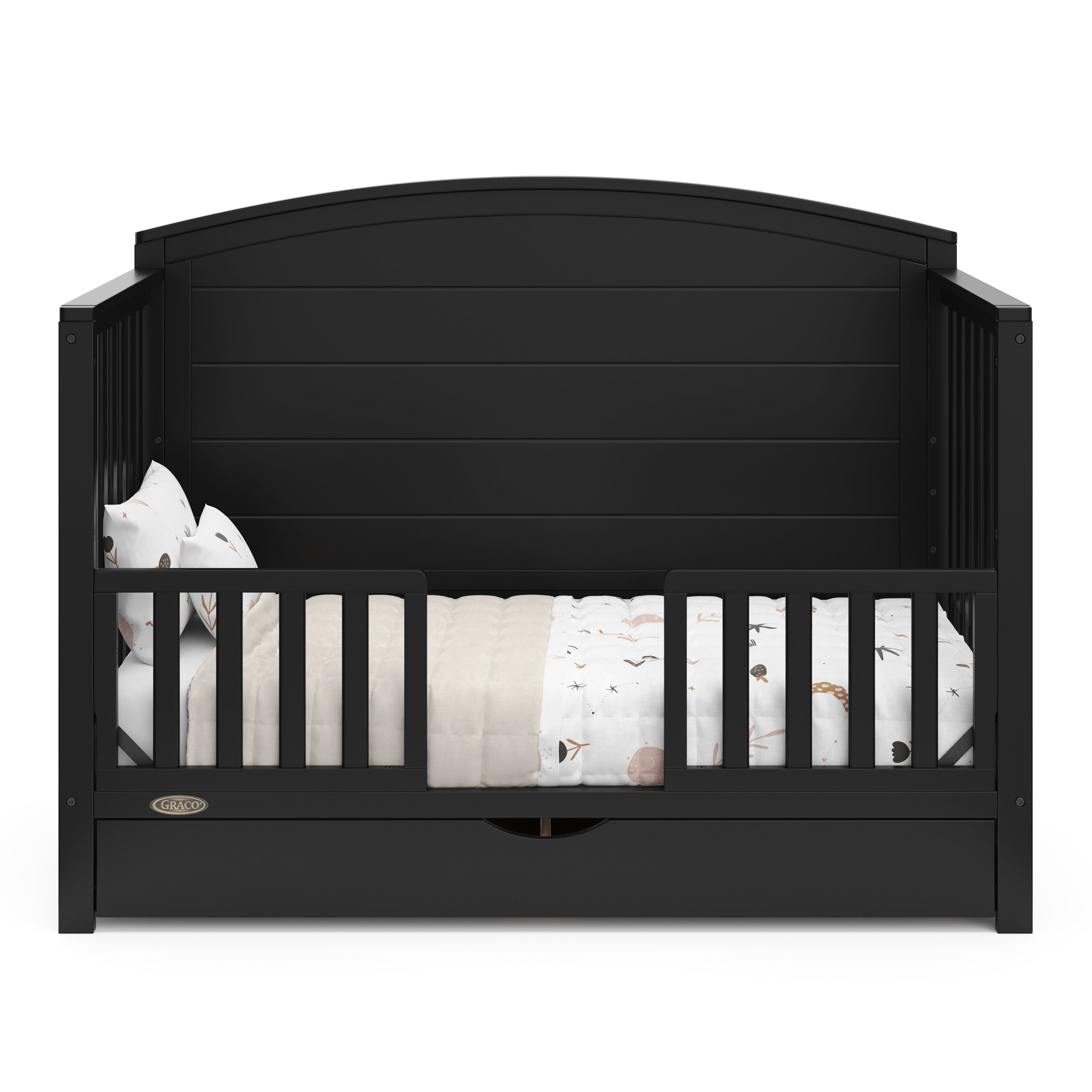 Convertible black crib transformed into a toddler bed with two guardrails