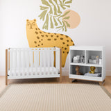 Nursery with a white crib accented by driftwood details and a matching white changing table