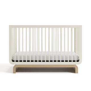 Two-tone frosted oat and natural wood baby crib, at a front-facing angle (Frosted Oat with Driftwood)