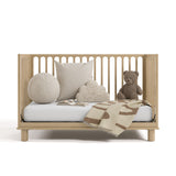 sicily driftwood crib daybed conversion with blanket, pillows, and teddy bear