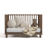 sicily hazelnut crib daybed conversion with blanket, pillows, and teddy bear