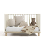 sicily frosted oat with driftwood crib daybed conversion with blanket, pillows, and teddy bear