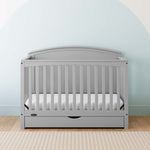 Convertible pebble gray crib in a nursery