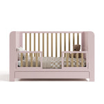 Read-with-Me crib blush with driftwood toddler bed conversion with pillows, bedding, and teddy bear