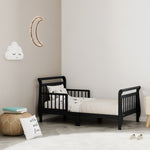 black toddler bed with guardrails in nursery