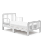 Angled view of a white toddler bed