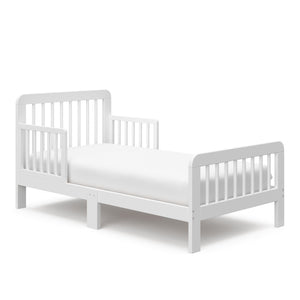 Angled view of a white toddler bed