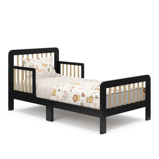 Side view of a black toddler bed with driftwood finish