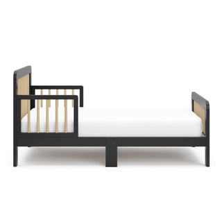 Side view of a black toddler bed with driftwood finish