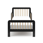 Front view of a black toddler bed with driftwood finish