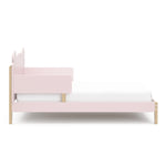 side view of a blush-colored toddler bed