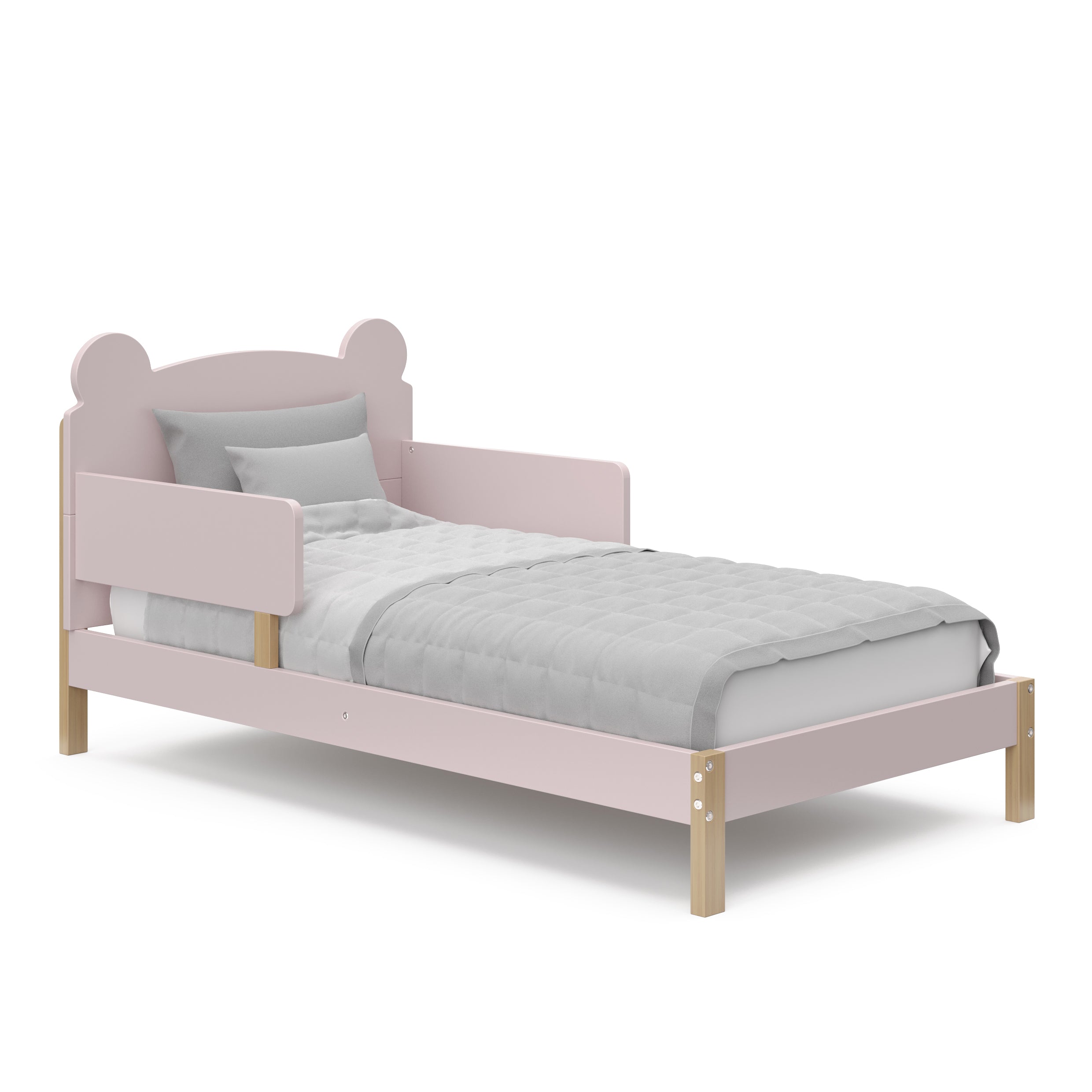 Angled view of a blush-colored toddler bed