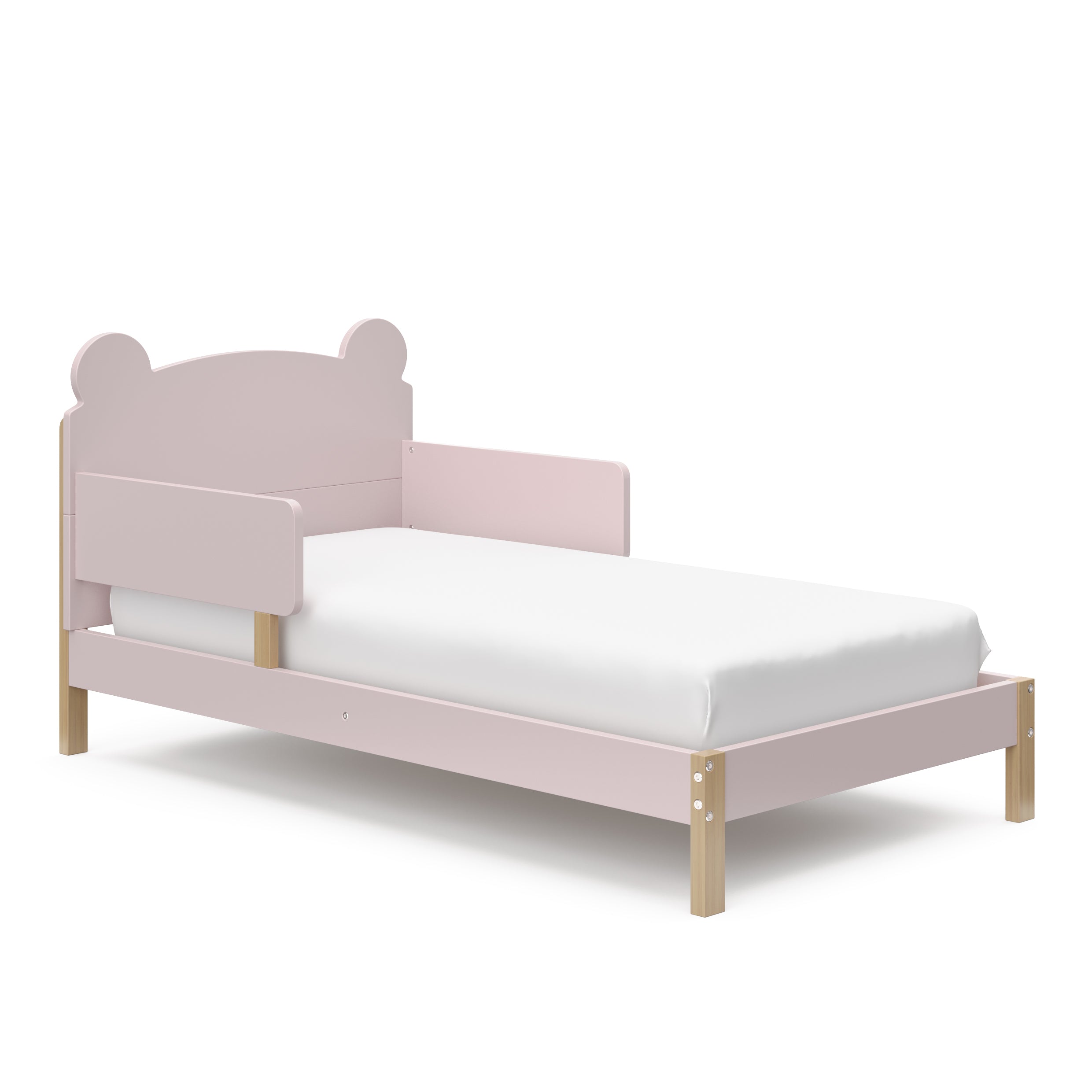 Angled view of a blush-colored toddler bed