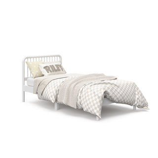 angled view of white twin bed with bedding